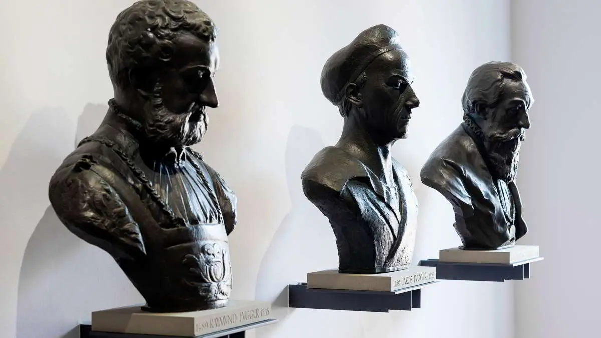 Fuggerbank Geschichte Tradition Drei schwarze Figuren auf einem Podest